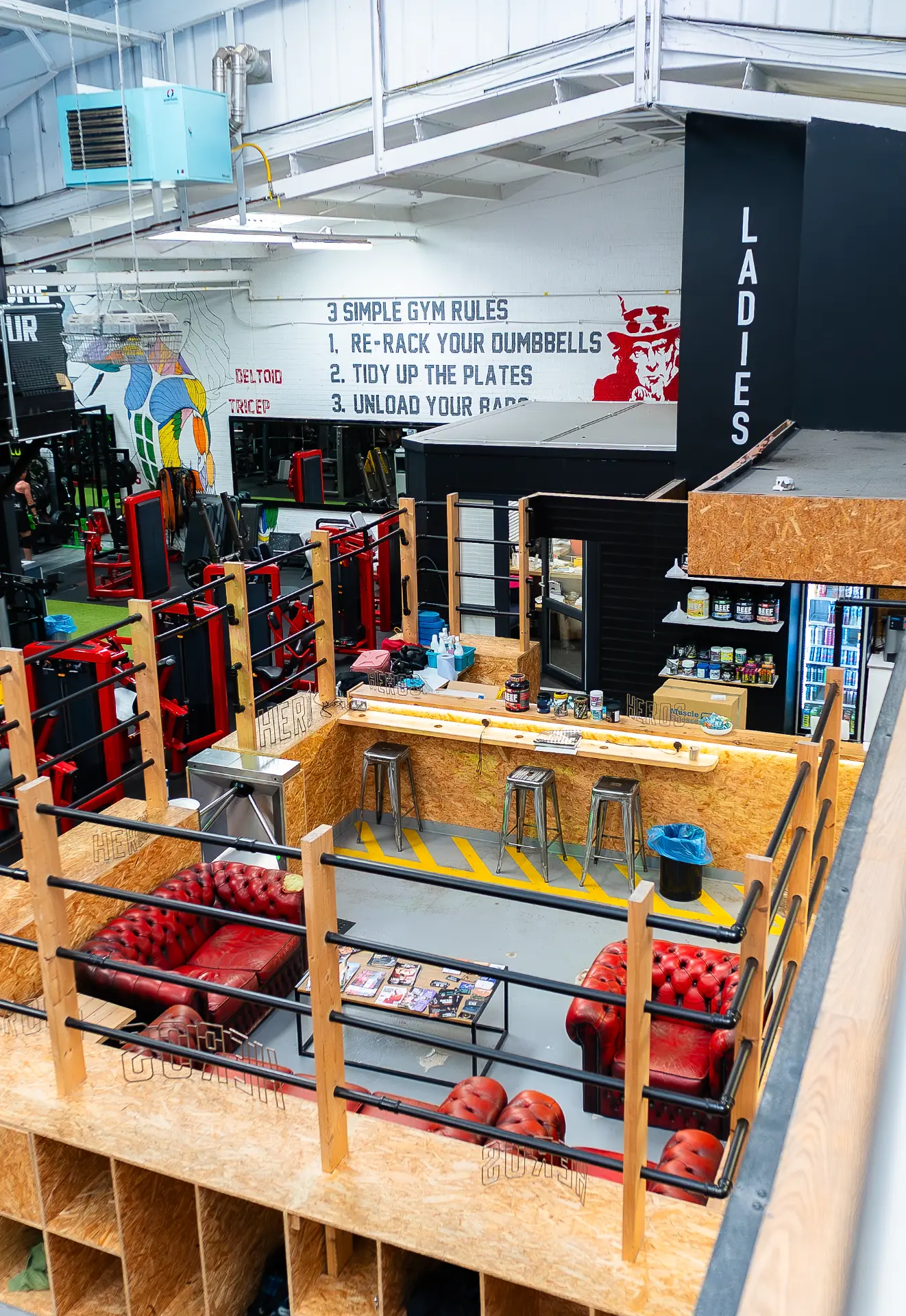 The '3 Simple Gym Rules' mural above the reception, shake bar and lounge at Heros