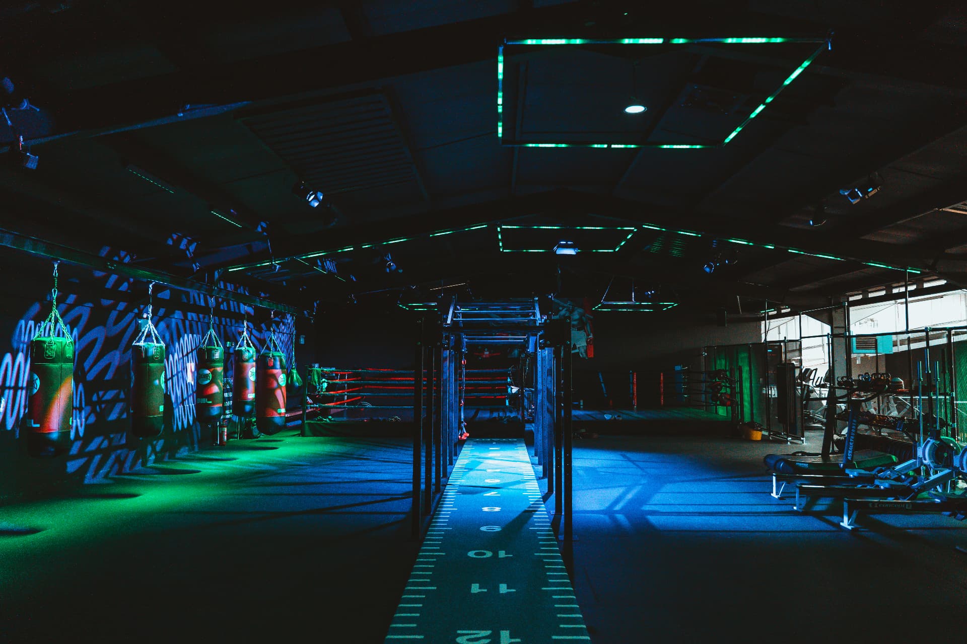 Boxing studio at Heros with heavy bags, competition ring and green LED lighting